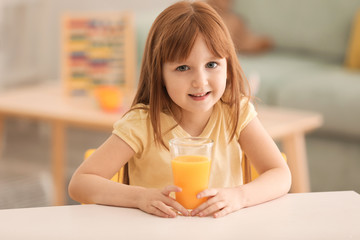 Funny little girl with citrus juice at home