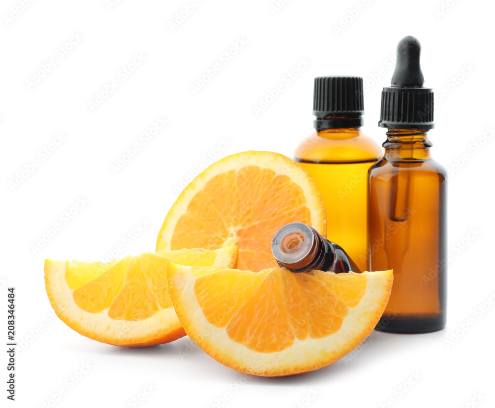 Bottles with citrus essential oil and sliced fruit on white background