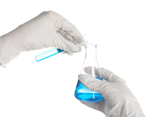 Woman pouring blue liquid from test tube into flask on white background