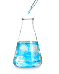 Dripping blue liquid into laboratory glassware on white background