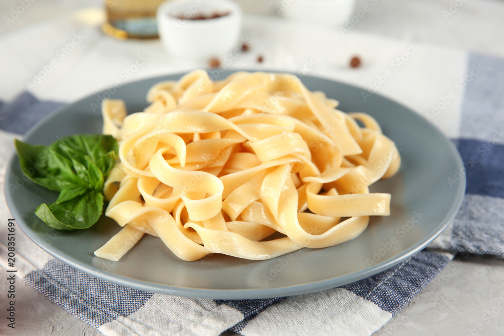 Plate of tasty pasta on table