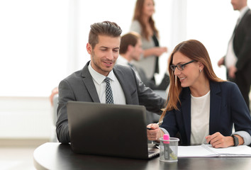 man and woman sitting at table in co-working office