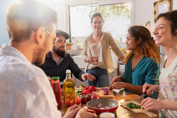 Multi-ethnic group of friends cooking lunch in the kitchen. 