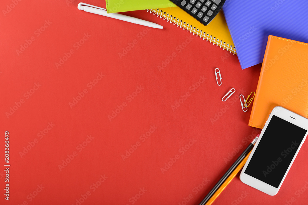 Workplace with smartphone, calculator and stationery on table