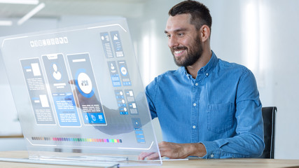 in the futuristic office creative designer works on the transparent computer display. screen shows p