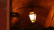 Stara lampa uliczna świecąca romantycznie w bramie