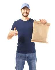 Delivery man holding paper bag with food on white background