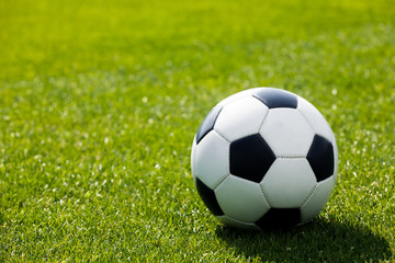 Football Ball on a Grass Field. Green Grass Soccer Pitch. Football Turf in the Background