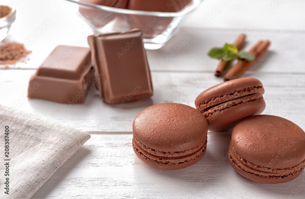 Delicious chocolate macarons on table
