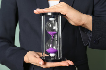 Woman holding hourglass, closeup. Time management concept