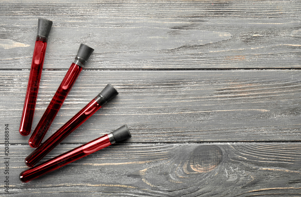 Test tubes with blood samples on wooden background