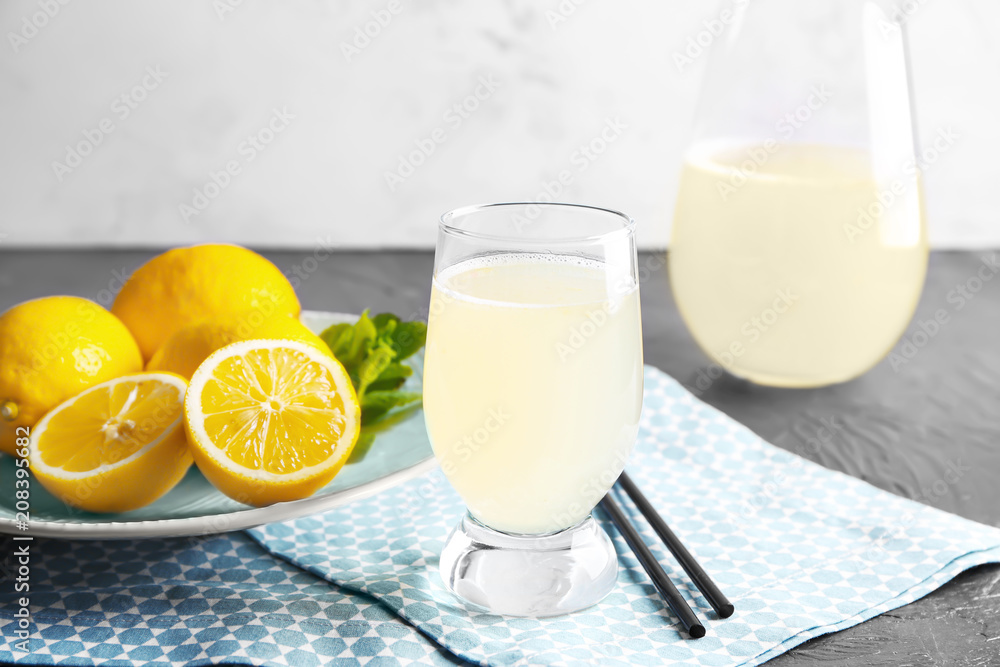 Fresh citrus drink in glassware and lemon on table