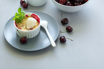 Wall Mural - Cherry crumble with oatmeal and ice cream in bowl on grey wooden desk. Summer healthy food