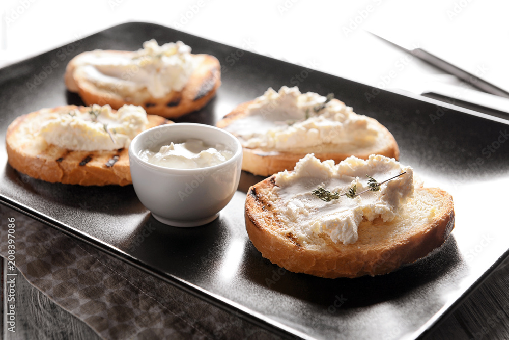 Delicious toasts with cream cheese on plate