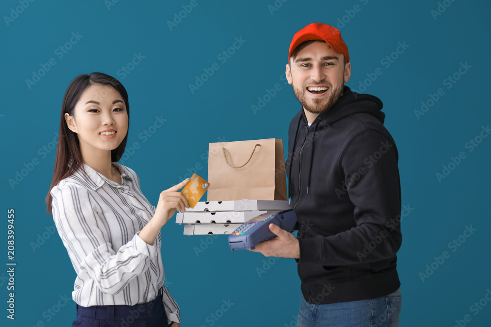 Young man delivering food to client on color background