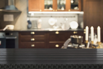 Blurred abstract background. Modern dark kitchen interior with tabletop for background and space for you.