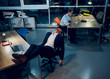 © Svyatoslav Lypynskyy - Young man having nap in office late night. Photo taken from high angle of businessman wearing suit falling asleep in his office chair after working all night with his colleague sitting in background.