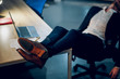 © Svyatoslav Lypynskyy - Sleeping businessmans feet up on office table. Cropped picture of young mans feet with brown leather shoes on lying on office desk with laptop in background.