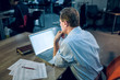 © Svyatoslav Lypynskyy - Middle aged office worker looking at computer screen. Photo of senior businessman sitting in office in late evening with laptop and some papers on his table taken from behind.