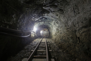 Underground glod ore mine shaft tunnel gallery with railway rails