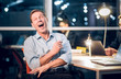 © Svyatoslav Lypynskyy - Portrait of happy laughing office worker. Cheerful senior businessman laughing out loud while sitting in office in middle of night.