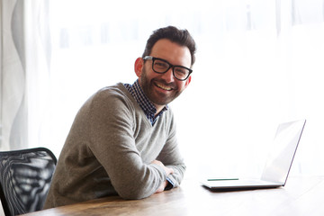 Wall Mural - happy businessman smiling with laptop