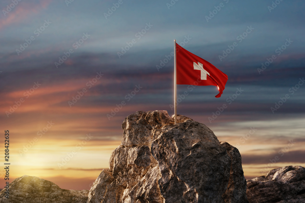 Wehende Schweizer Fahne auf Bergspitze im wunderschönen Abendrot - obrazy, fototapety, plakaty 