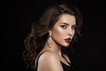 Fashion glamorous portrait of a girl on a dark background. Elegant hairstyle, bright makeup and lip color. Hollywood picture.