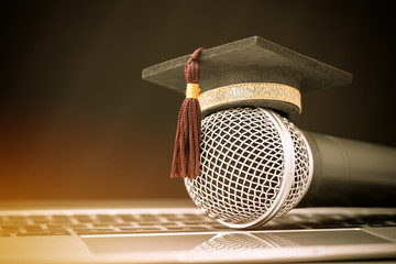 graduate study or education knowledge concept: graduated cap put on microphones front of table of ke