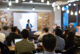 Fototapeta  - Audience Watching a Presentation. Defocused Blurred Presenter During Conference Meeting