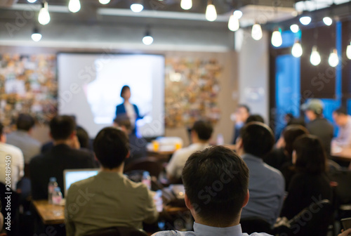 Audience Watching a Presentation. Defocused Blurred Presenter During Conference Meeting