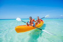 Happy Boy And Girl Kayaking At Tropical Sea On Yellow Kayak