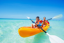 Happy Boy And Girl Kayaking At Tropical Sea On Yellow Kayak