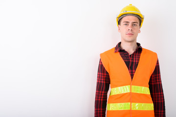 Wall Mural - Young handsome man construction worker against white background