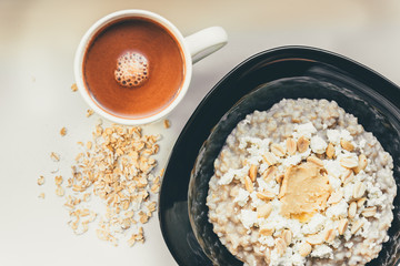 Wall Mural - Homemade oatmeal with honey, peanut butter, peanut, flax seeds and cottage cheese on wooden background. Healthy breakfast.