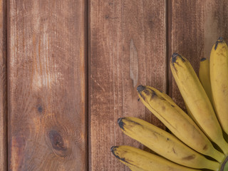 Wall Mural - copy space for text with mini small bananas on a wooden surface.