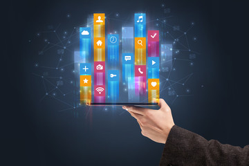 Businessman hand using phone with flying application icons around
