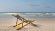 An yellow beach chair rests on the white sand of the beach and Bright blue sea with white clouds, at Rayong Thailand