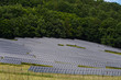 lots of solar collectors and green trees in the background