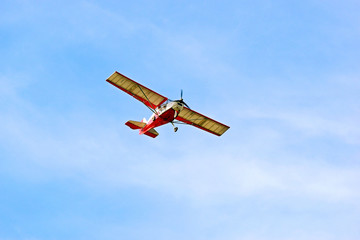 Small red airplane on a background of blue sky.