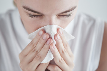 Rhinitis. Girl with napkin on white background