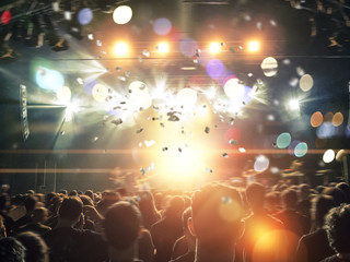 Wall Mural - Concert crowd with lens flare and haze, stage is visible ahead.