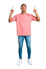 Standing young african american man pointing with the index finger a great idea and looking up on isolated white background