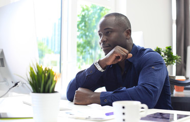 Wall Mural - Portrait of a happy African American entrepreneur displaying computer in office.