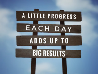 Wall Mural - Motivational and inspirational quote - ‘A little progress each day adds up to big results’ on plank signage. With vintage styled background.