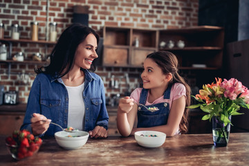 mother and daughter eating corn flakes