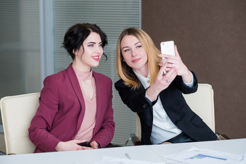 Wall Mural - selfie at work. business women have fun at the office meeting taking photos of themselves. successful managers sharing their lifestyle. coaching.