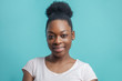 headshot of cheerful black female student with hair bun. American hipster girl in white T-shirt