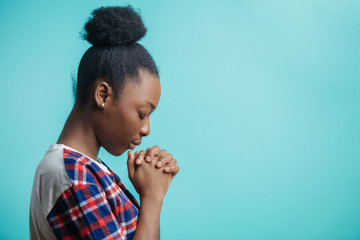 close up side view portrait of black girl with lively faith. expiatoryfaith. mixed race girl is asking forgiveness because she has done a lot of mistakes and sins. copyspace. profile