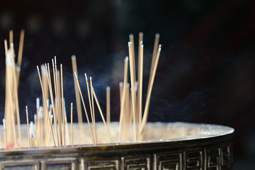 burning incenses or joss sticks on black background